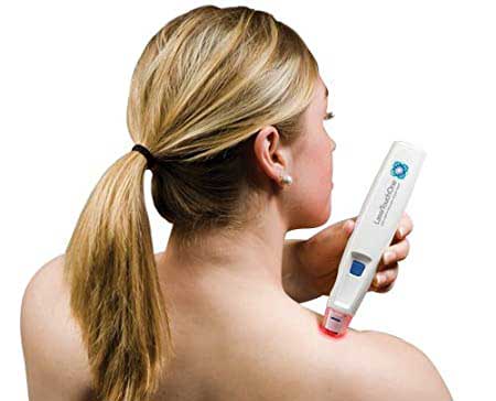 A woman treating herself with Low-level laser therapy